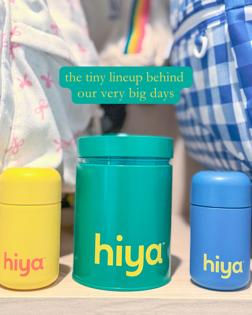 Three colorful containers labeled hiya (yellow, green, and blue) are displayed on a shelf, with a blurred background of patterned bags and fabric. Text above reads: the tiny lineup behind our very big days..