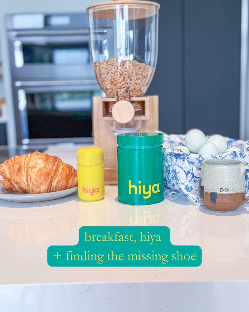 A breakfast scene with a croissant, a canister and bottle labeled hiya, a cereal dispenser, a bowl of eggs, and a mug. Text on the image says, breakfast, hiya + finding the missing shoe..